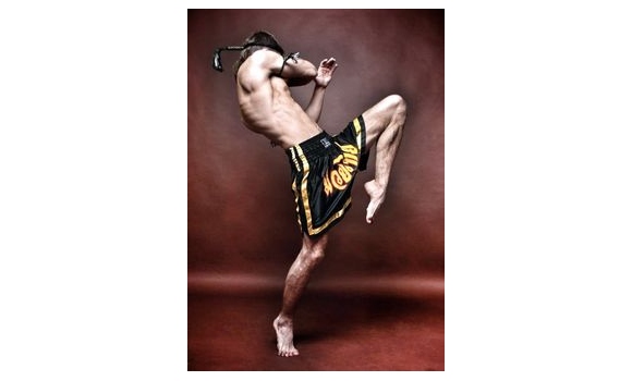 Pretty Muay Thai female boxer in attack pose. Fitness young woman boxing  training on black background, closeup Stock Photo - Alamy